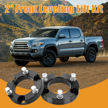 Modified off-road vehicle with upgraded front lift kit and oversized tires, driving on rough terrain with improved ground clearance